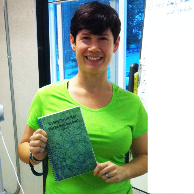 Smiling girl in green shirt holding blue and green custom fitness journal