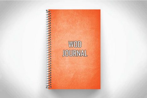 Orange WOD journal for crossfit workouts on gray background