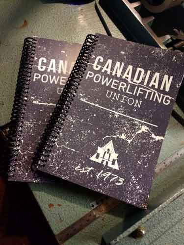 A couple canadian powerlifting union weightlifting journals on a cutter