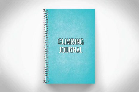 teal rock climbing workout journal and training log on gray background
